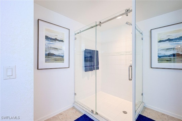 full bath with tile patterned floors, a shower stall, and baseboards