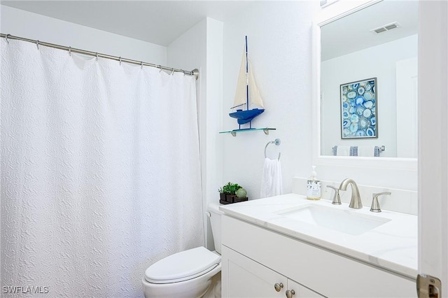 bathroom featuring visible vents, toilet, and vanity