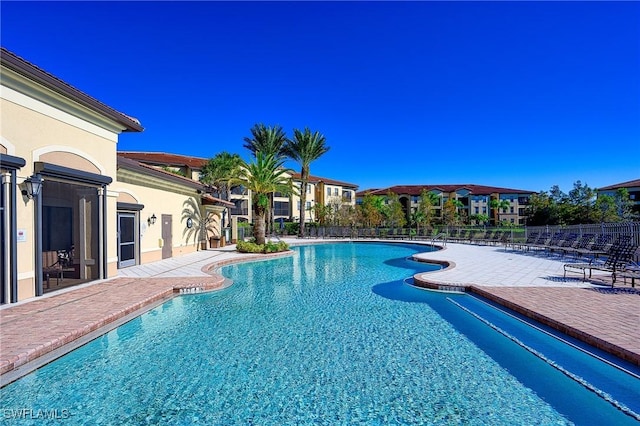 community pool featuring fence and a patio area