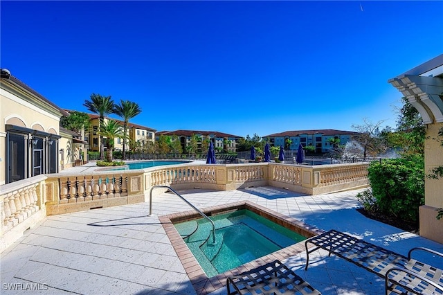 pool with a residential view, a patio, fence, and a hot tub