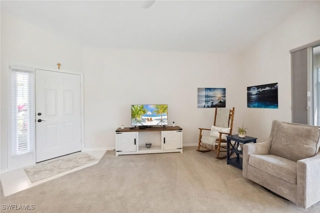 living area featuring light colored carpet and baseboards