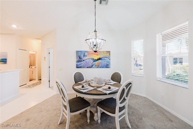 dining room with light carpet, visible vents, baseboards, and an inviting chandelier