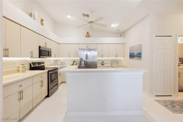 kitchen with visible vents, ceiling fan, stainless steel appliances, light countertops, and a center island