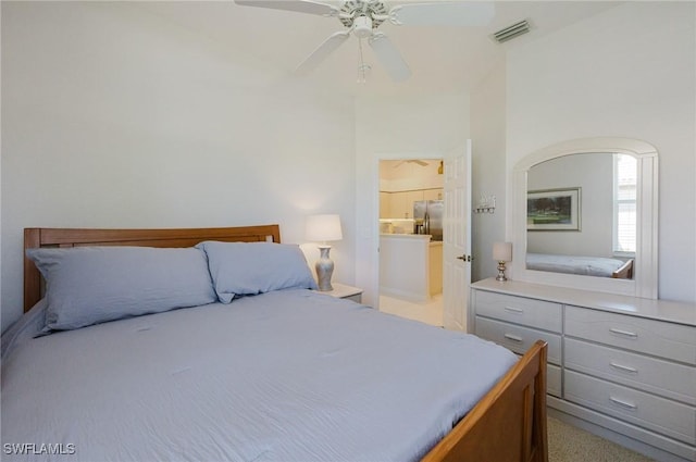 bedroom with connected bathroom, visible vents, stainless steel fridge, and ceiling fan