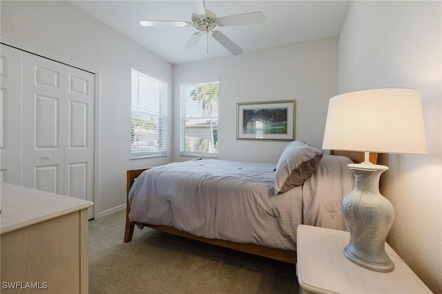 bedroom with a ceiling fan, light colored carpet, a closet, and baseboards