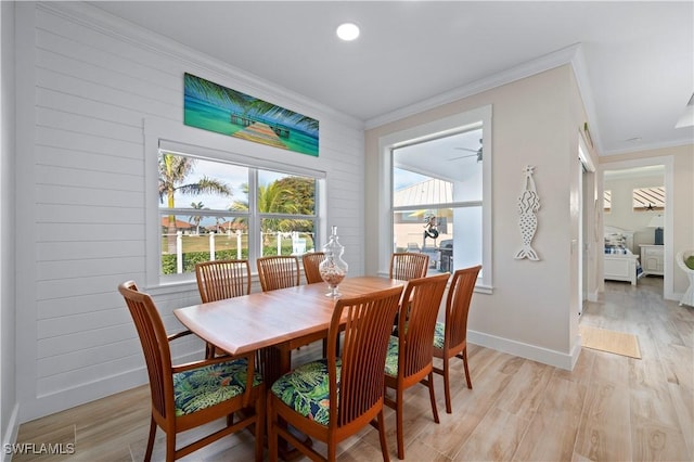 dining space with light wood-style flooring, crown molding, and baseboards