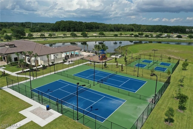 view of tennis court featuring a water view and fence