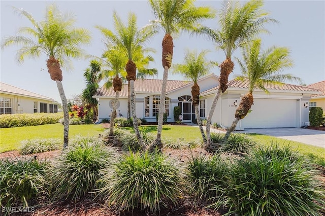 view of front of house with a tile roof, an attached garage, concrete driveway, and a front yard