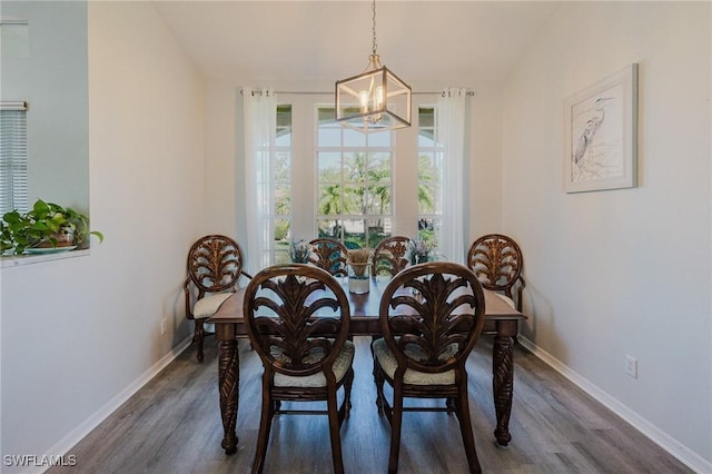 dining room with dark wood-style floors, a notable chandelier, and baseboards