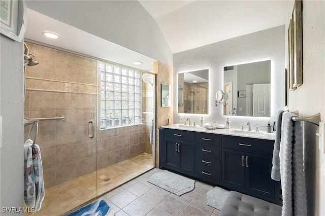 bathroom featuring a shower stall, lofted ceiling, double vanity, tile patterned floors, and a sink