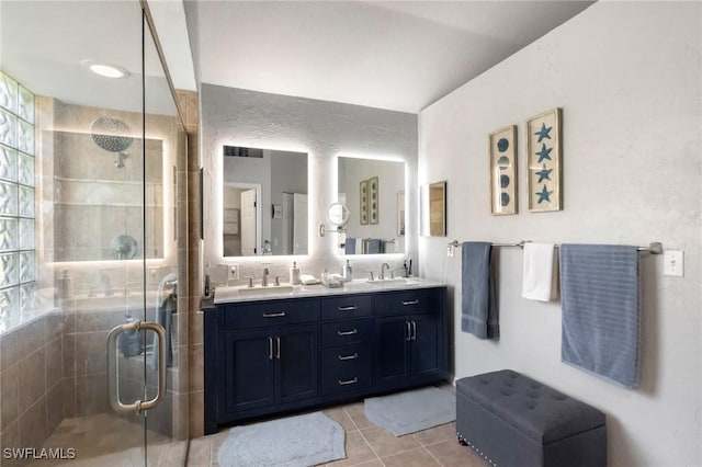 bathroom featuring a sink, a stall shower, and double vanity