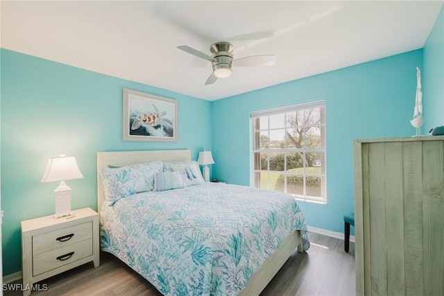 bedroom with a ceiling fan, baseboards, and wood finished floors