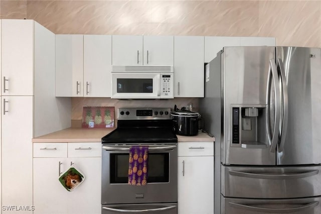 kitchen with white cabinets, appliances with stainless steel finishes, and light countertops