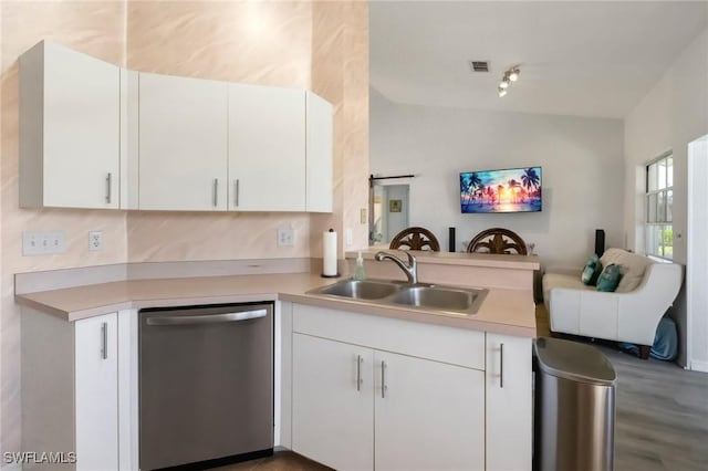 kitchen featuring visible vents, a peninsula, a sink, stainless steel dishwasher, and open floor plan