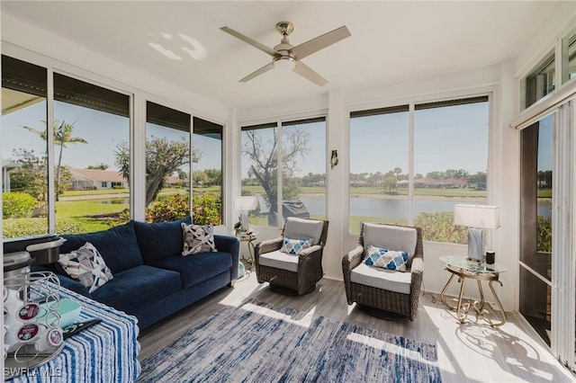 sunroom featuring a water view and ceiling fan