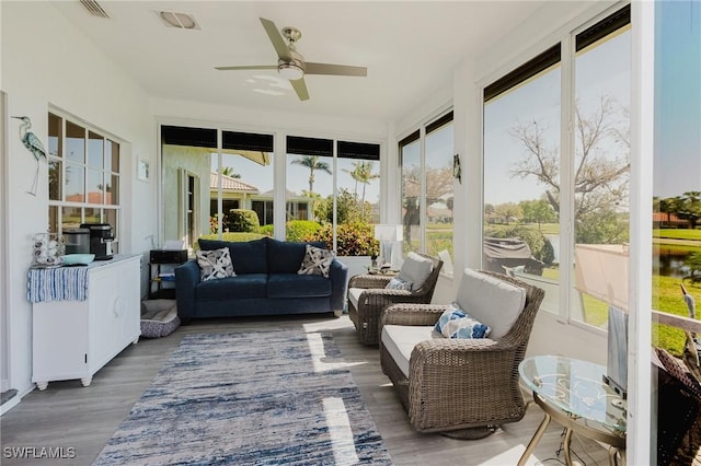 sunroom featuring a wealth of natural light, visible vents, and a ceiling fan