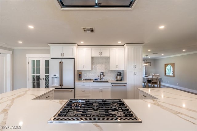 2237 Kings Lake Blvd, Naples, FL 34112 - kitchen with high end white fridge, a sink, ornamental molding, white cabinets, and tasteful backsplash