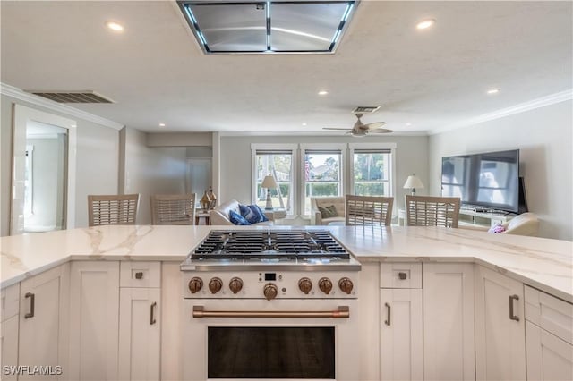 kitchen with visible vents, light stone countertops, open floor plan, high end white range, and white cabinetry