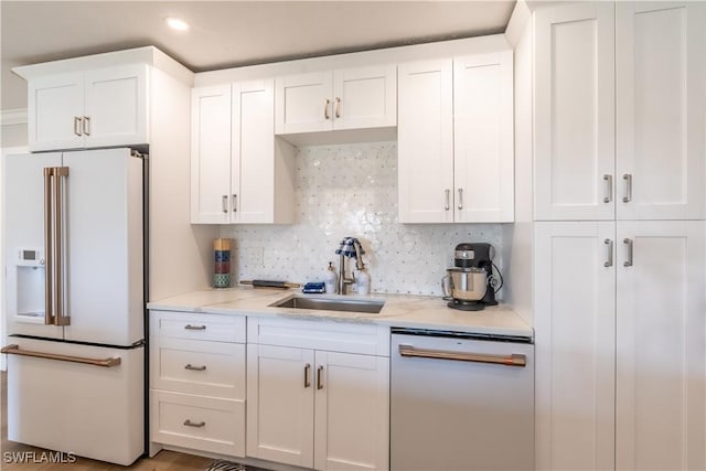 kitchen with a sink, decorative backsplash, white appliances, and white cabinets