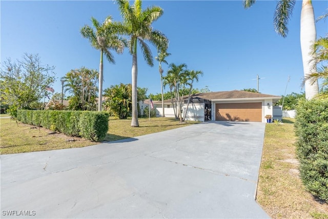 single story home featuring driveway, a front lawn, and a garage