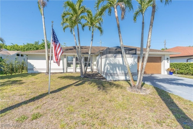 view of front of home with a front yard, an attached garage, stucco siding, concrete driveway, and a lanai