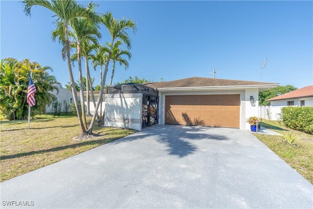 view of front of home with a front lawn, fence, stucco siding, a garage, and driveway