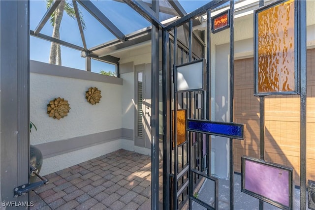 view of patio featuring glass enclosure