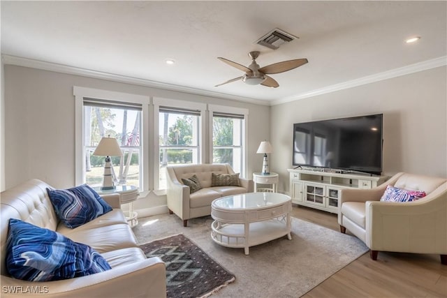 living area with visible vents, wood finished floors, ceiling fan, and ornamental molding