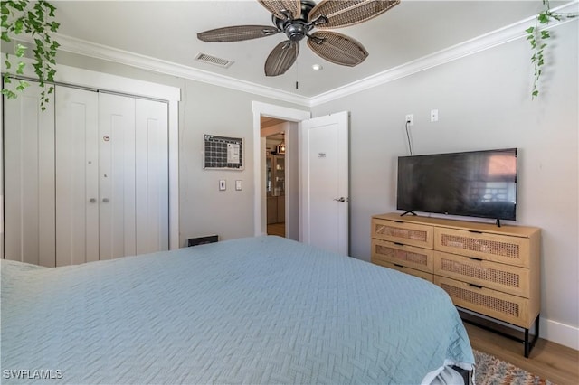 bedroom featuring visible vents, crown molding, a ceiling fan, and wood finished floors