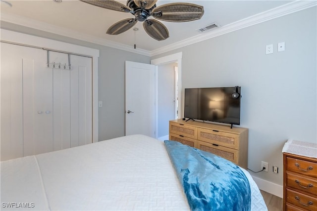 bedroom featuring visible vents, a ceiling fan, a closet, crown molding, and baseboards