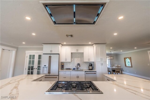 2237 Kings Lake Blvd, Naples, FL 34112 - kitchen with stainless steel appliances, a sink, french doors, crown molding, and white cabinets