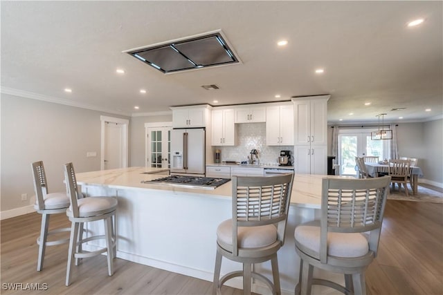 kitchen featuring crown molding, white cabinets, french doors, and high end white fridge