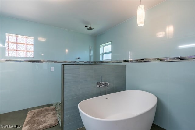 2237 Kings Lake Blvd, Naples, FL 34112 - bathroom featuring tile walls and a freestanding tub