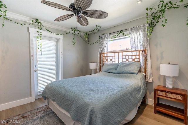 bedroom featuring a ceiling fan, baseboards, and light wood finished floors