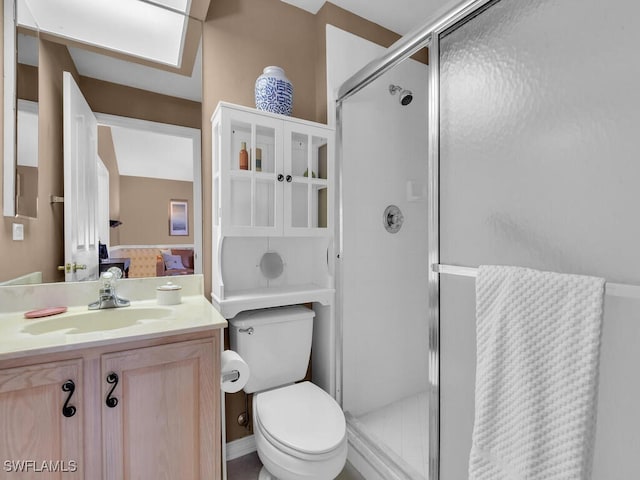 bathroom featuring a stall shower, toilet, and vanity