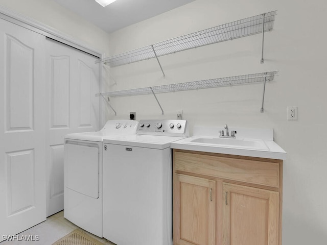 washroom with light tile patterned floors, separate washer and dryer, and a sink