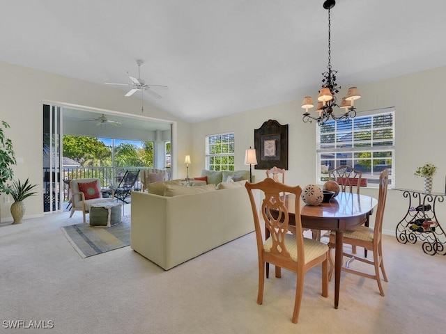 dining space featuring ceiling fan with notable chandelier, vaulted ceiling, light colored carpet, and baseboards