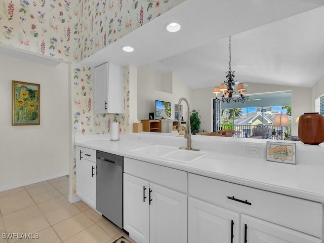 kitchen with dishwasher, light countertops, lofted ceiling, white cabinetry, and a sink