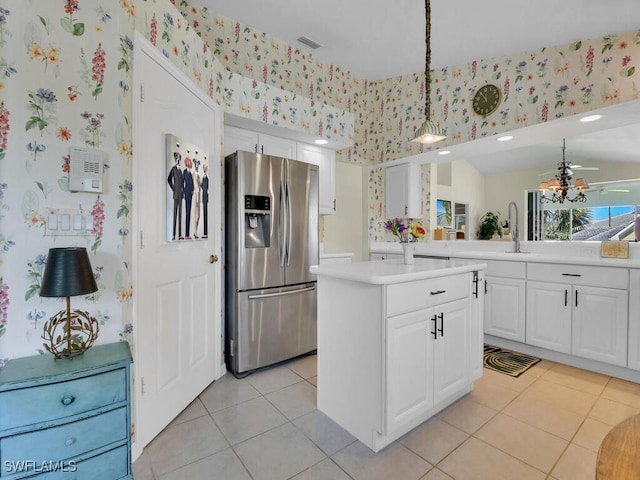 kitchen featuring visible vents, wallpapered walls, light countertops, white cabinets, and stainless steel fridge