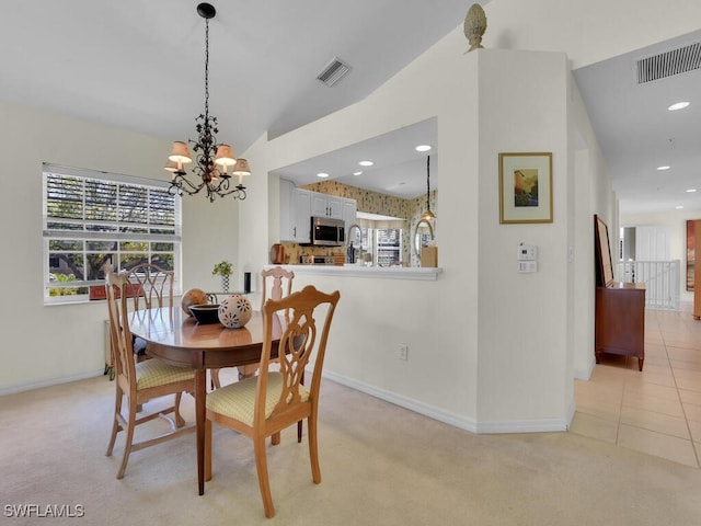 dining room with visible vents, light colored carpet, and baseboards