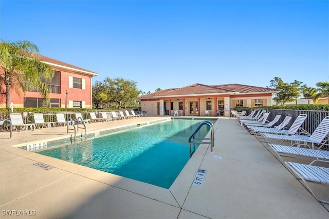 community pool with a patio and fence