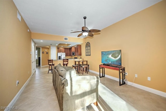 living area with light tile patterned floors, baseboards, and visible vents