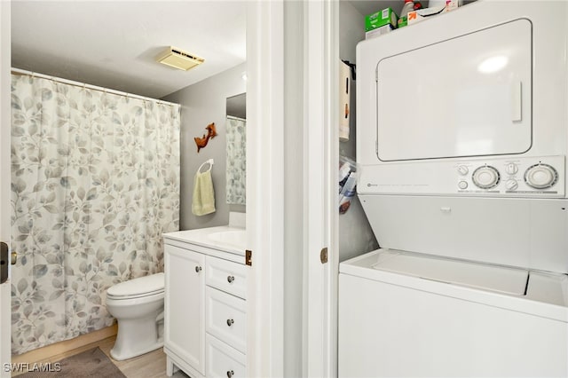 washroom with laundry area, stacked washer / dryer, and visible vents