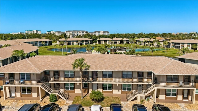 exterior space featuring stairway, a water view, and a residential view