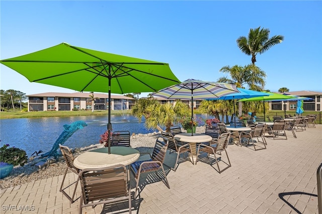 view of patio with outdoor dining area and a water view