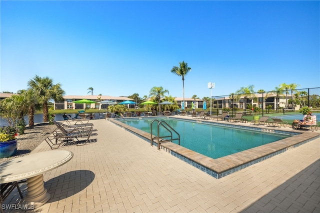 pool with a patio and fence