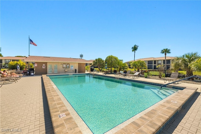 community pool featuring french doors and a patio