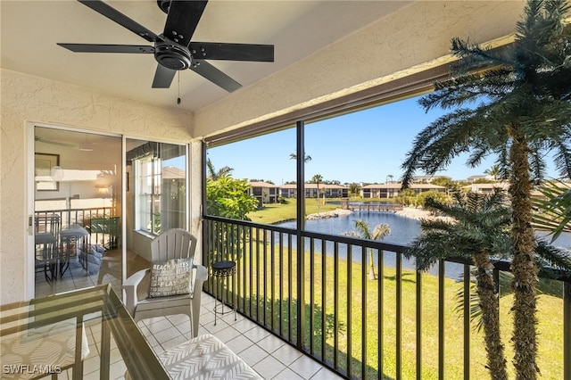 balcony featuring a water view and a ceiling fan