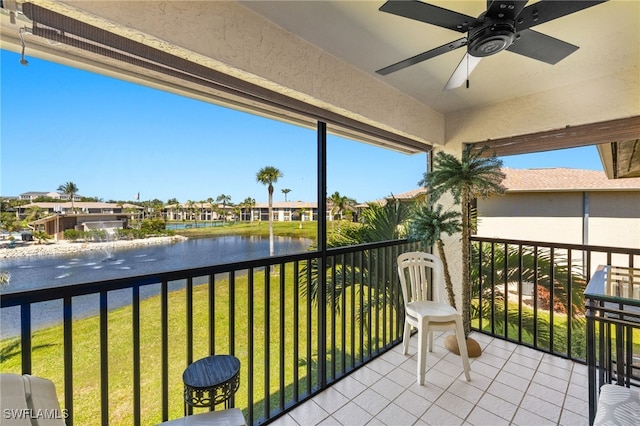 balcony featuring a water view and a ceiling fan