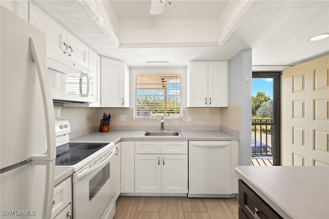 kitchen with white appliances, light countertops, tasteful backsplash, and a sink